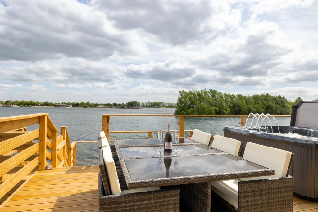 Outdoor dining tables on the decking by the lake